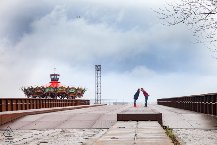 Ein Paar aus Nantes, Frankreich, das sich während eines Verlobungsfotoshootings unter den Wolken küsst