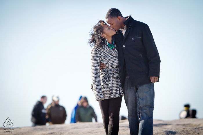 engagement portraits with a couple Kissing on top of Stone Mountain