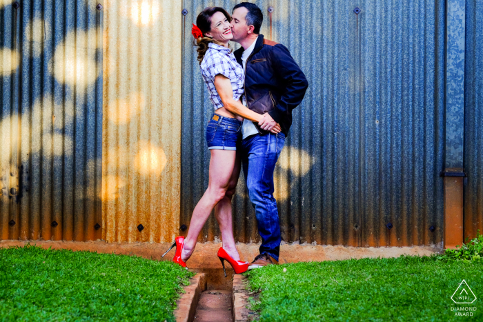 A vibrant, warm and colourful couple against an industrial, cold and grey backdrop, playing on contrasts at the Prince Charles Airport, Harare, Zimbabwe