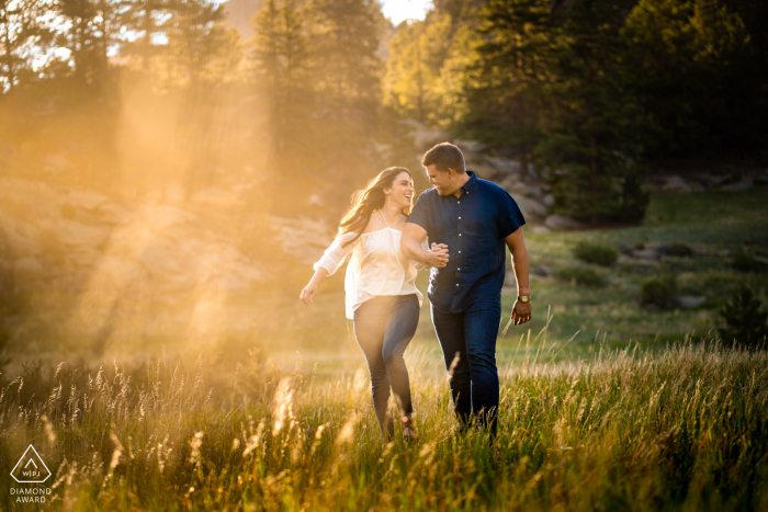 Un jeune couple marchent ensemble pendant leur séance photo de fiançailles à Lake George, Colorado