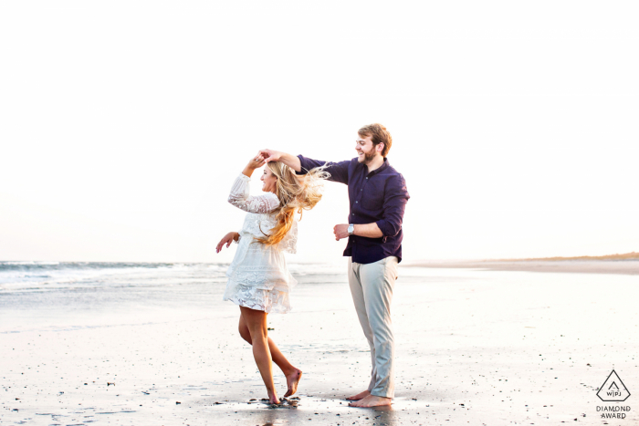 Avalon, New Jersey beach engagement session with a couple spinning and dancing by the water's edge at the beach