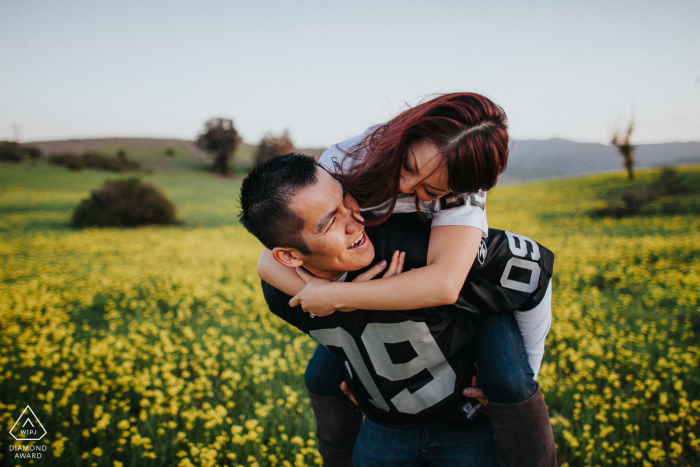 San Jose, California engagement image session with a couple of Raiders fans in a yellow field of flowers San Jose, California engagement session with a couple of Raiders fans in a yellow field of flowers