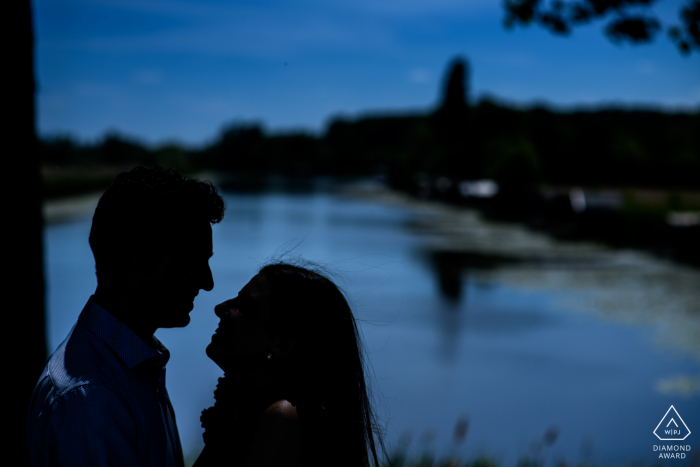 de klinge Paar posiert für voreheliche Porträts in der Abenddämmerung am Wasser