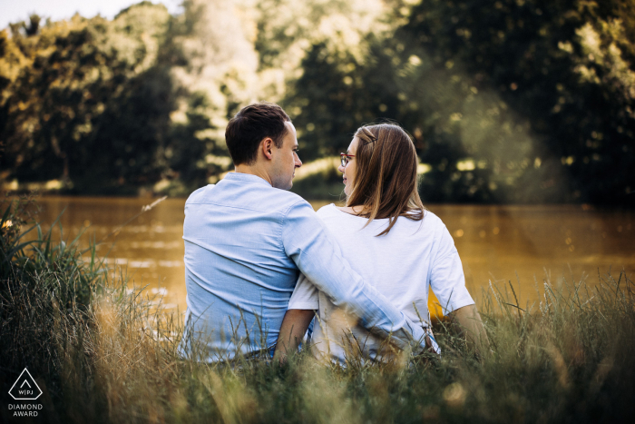 Parque Mickiewicz, Lodz, Polônia Casal à beira do lago usando uma foto traseira durante a sessão de noivado