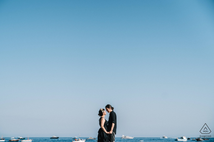 Séance photo de fiançailles à Bari sous le ciel bleu des Pouilles, avec des bateaux sur l'eau