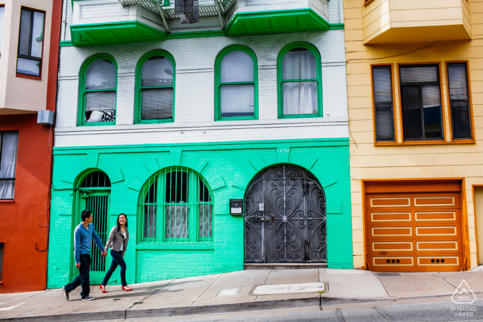 Verlobtes Ehepaar aus San Francisco, CA, das während der Verlobungssitzung für Bilder auf der Stadtstraße spaziert