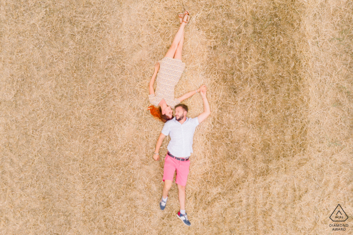 Vendée, Francia pareja acostada en su campo de trigo recién cortado en el courtyside francés, desde arriba a través de drone