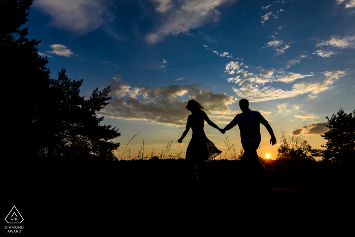 Heather vicino a Eindhoven Silhouette immagine di una coppia in esecuzione al tramonto.