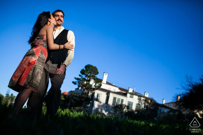 Retrato de compromiso de cielo azul CA de la pareja en un suave beso amoroso en SF, CA