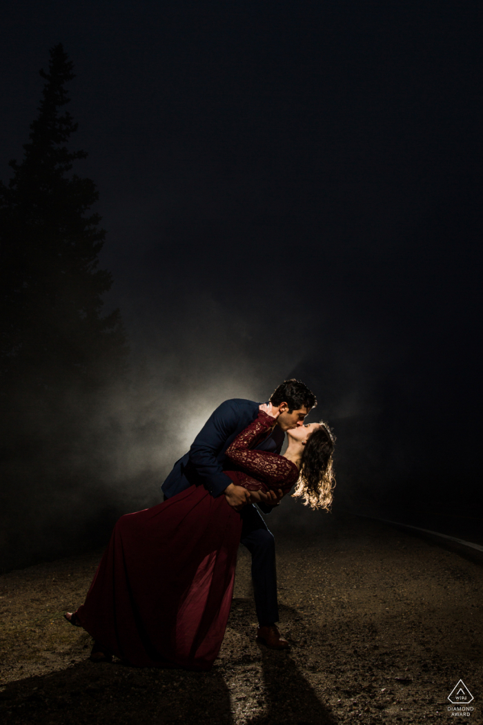 Squaw Pass Colorado Couple kissing in the fog at night with a light Squaw Pass Colorado Couple kissing in the fog at night with a light