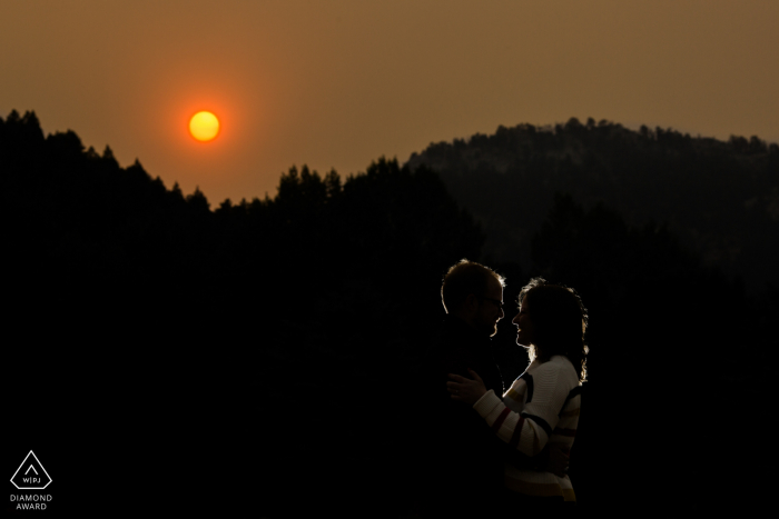 Couple backlit with orange sun due to wildfires during this Evergreen Lakehouse engagement session