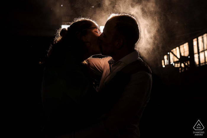 Intimate engagement portrait inside the factory of Old steel factory in Alblasserdam with a lot of dust