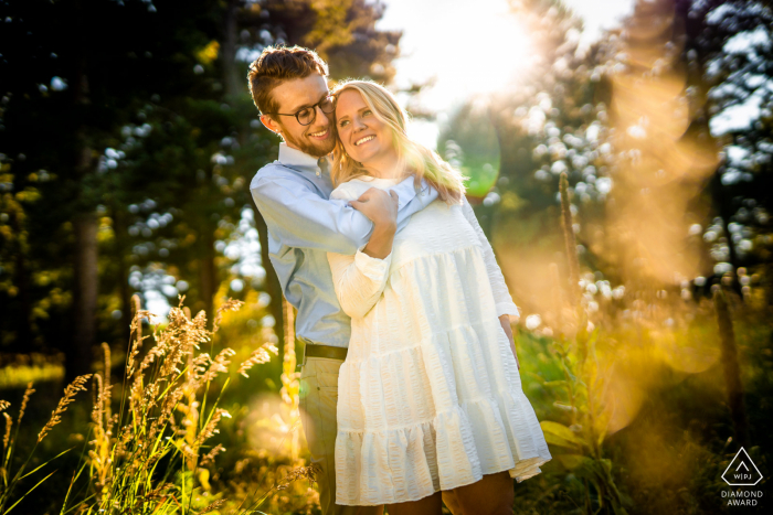 Pareja abrazada durante su sesión de compromiso en Meyer Ranch Park en Morrison, Colorado