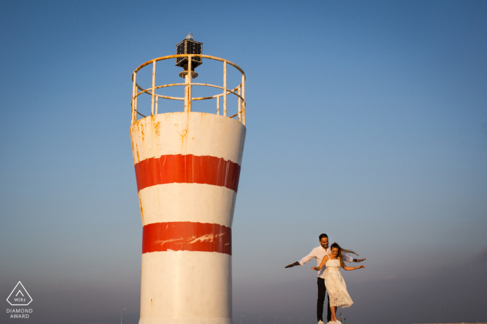 Izmir, Turkey sea light flying couple portrait session by the lighthouse tower Izmir, Turkey sea light flying couple portrait session by the lighthouse tower