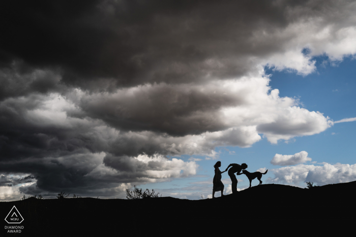 Ile de France, France engagement photo of a couple against the sky with a dog Ile de France, France engagement photo of a couple against the sky with a dog