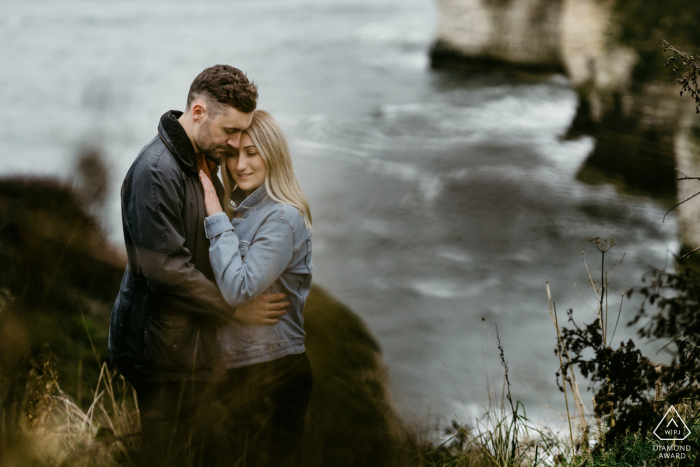 England pre-wedding photo session with an engaged couple hanging out over the waters of Flamborough Point - A Couple together on cliff top