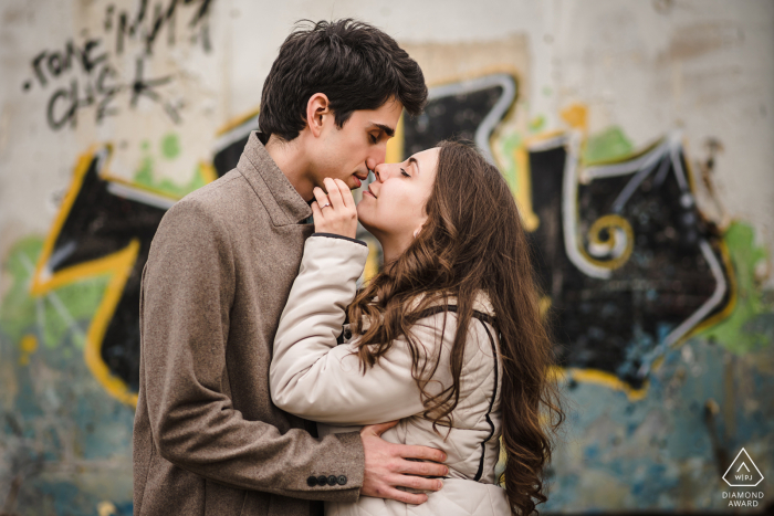 BG engagement photo shoot of a couple nuzzling with grafitti as their backdrop in Sofia, Bulgaria