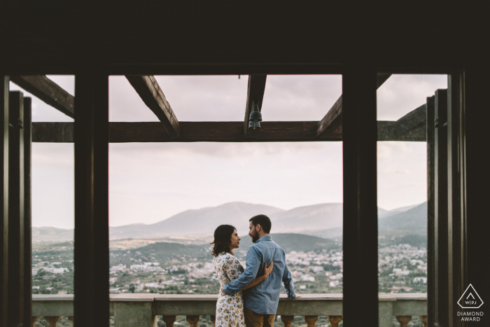 GR Verlobungsfotoshooting & Vorhochzeitssitzung in Athen, Griechenland von einem Paar, das auf einem Balkon mit toller Aussicht steht