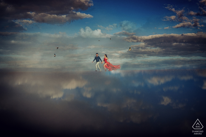 Goias wedding photographer at a pre-wedding session with an engaged couple running through the clouds high above Caraíba 