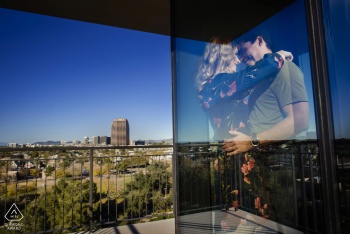 Pareja de Phoenix, Arizona en su casa reflejada en vidrio durante la sesión de fotos de compromiso antes del matrimonio