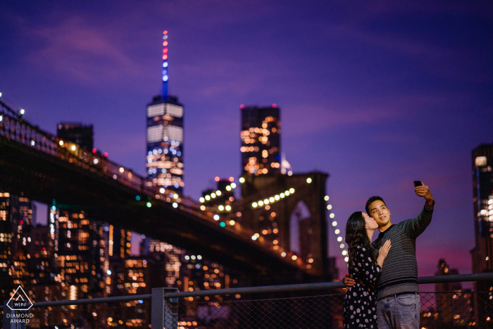 dumbo, couple nyc prenant un selfie au crépuscule lors d'une séance photo avant le mariage