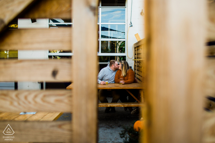 Pareja cervecera de la calle Zuni besándose en el patio de la cervecería para una sesión fotográfica antes del matrimonio