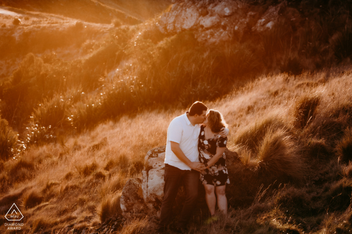 Port Hills Christchurch Nouvelle-Zélande Couple s'embrassant lors d'une séance photo de fiançailles