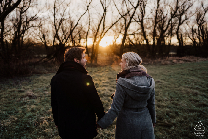 Mülheim an der Ruhr, Deutschland außerhalb der Waldbildsession vor dem Hochzeitstag beim Händchenhalten während des Sonnenaufgangs