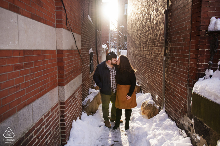 South End, Boston, Massachusetts mini shoot photo urbaine avant le jour du mariage d'un couple dans une ruelle avec de la neige fraîche et du soleil couchant