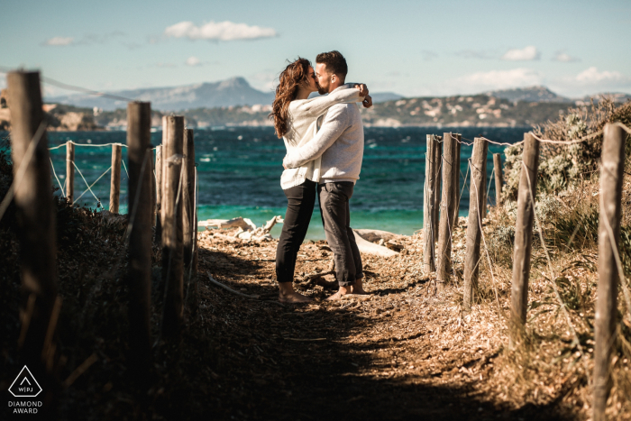 Sessão fotográfica em mini-praia do mar francês antes do dia do casamento de um casal se beijando na praia