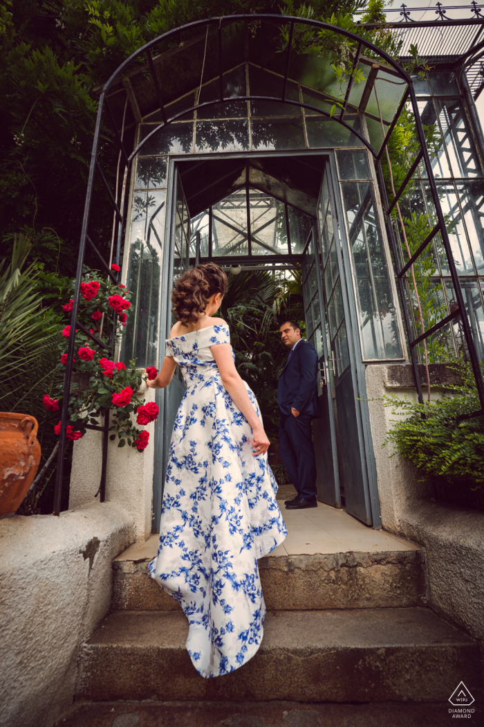 Pequena sessão fotográfica interna do Jardim Botânico com o casal antes do dia do casamento mostrando A mulher sobe as escadas em direção ao homem