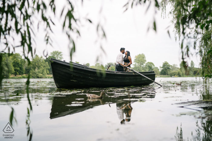 Hever Castle, Inghilterra mini sessione di fotografia di coppia in spiaggia prima del giorno del matrimonio baciarsi su una barca