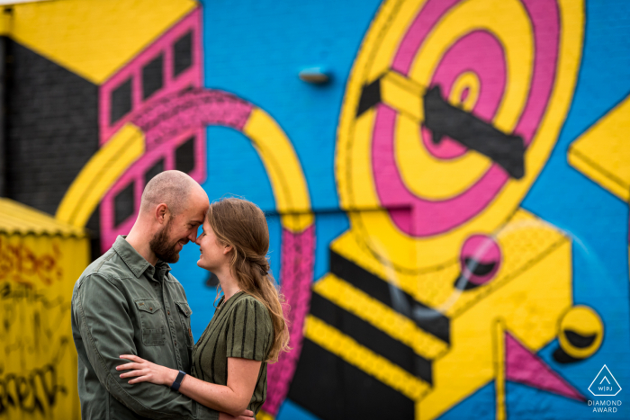 Breda Mini-Urban-Fotoshooting vor dem Hochzeitstag, das zeigt, wie das Paar posiert, im Hintergrund sieht man eine Graffiti-Wand