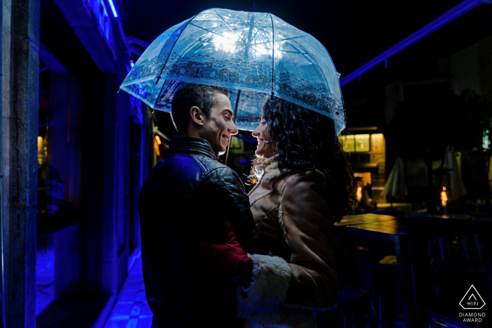 Jaén, Espagne mini-séance photo urbaine avant le jour du mariage la nuit sous un parapluie avec des lumières bleues