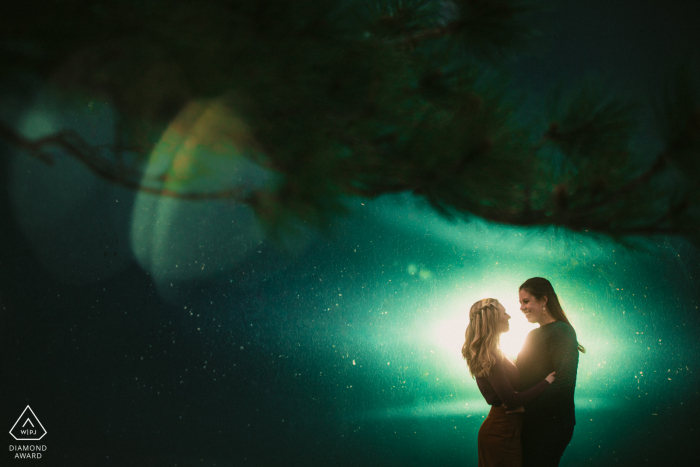 Mini-sessão de fotos artísticas do casal em Boulder antes do dia do casamento, resultando em um retrato iluminado em frente a uma torre de água texturizada