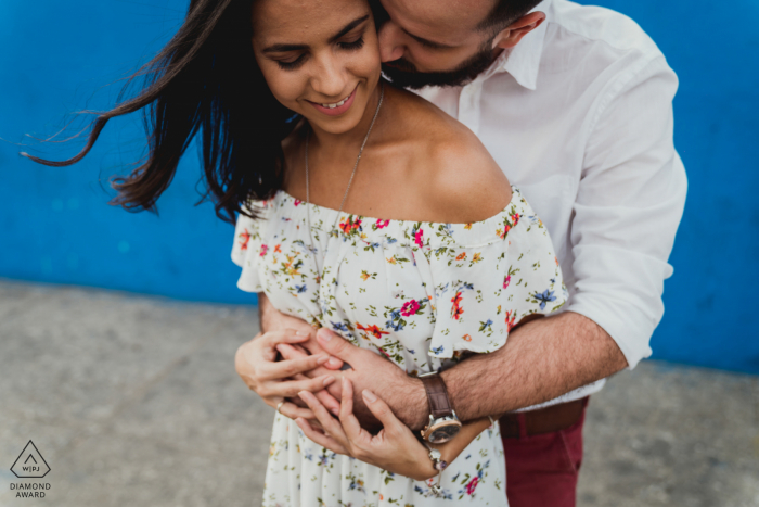 Mini-Fotosession für ein intimes Paar in Kuba vor dem Hochzeitstag im Wind vor einer blau gestrichenen Wand