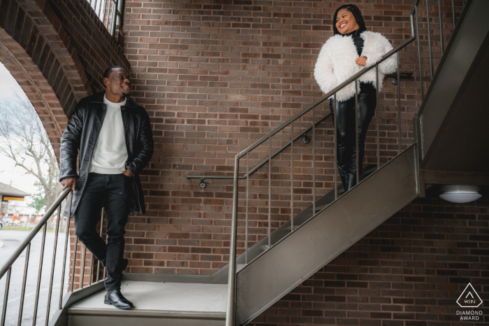 Sevierville, TN, mini sesión de fotos urbanas antes del día de la boda mientras la pareja se mira mientras están parados en unas escaleras en el centro de Sevierville.