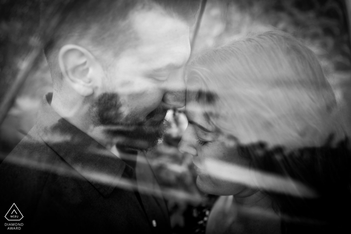 Sessão de fotos em preto e branco em Florença, Toscana, com o casal se beijando sob o guarda-chuva