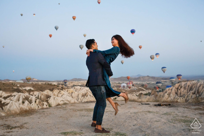 Cappadoce, Turquie Micro session de photo de montagne en plein air avant le jour du mariage avec un ascenseur ludique alors que les ballons décollent également