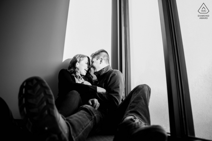 Fargo, Dakota du Nord, petite séance photo en intérieur avec le couple avant le jour du mariage avec un rire pendant une séance de diplôme négatif