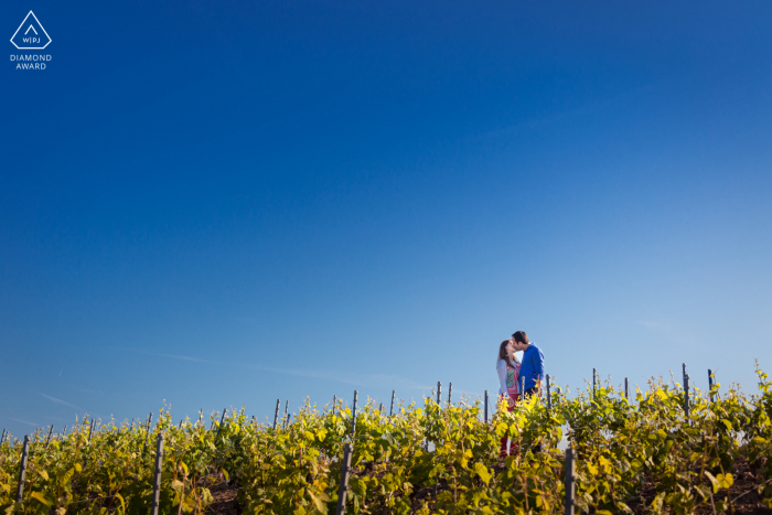 Champagner-Paarporträt in den Weinbergen unter dem großen blauen, minimalistischen Himmel