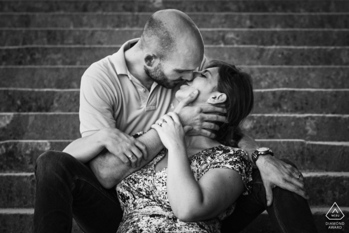 Retrato de pareja de París en blanco y negro con algunos tiernos besos en los escalones de piedra