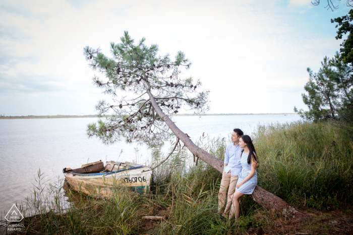 Retrato de casal em Bordéus olhando para o mar com um pequeno barco nas proximidades