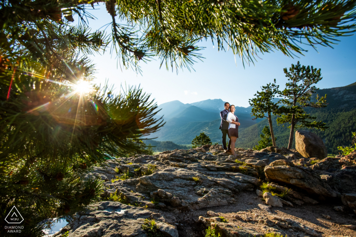 Estes Park, Colorado, une séance photo de couple de montagne faite alors que le soleil se couche derrière les montagnes rocheuses, le couple pose pour un portrait de fiançailles.