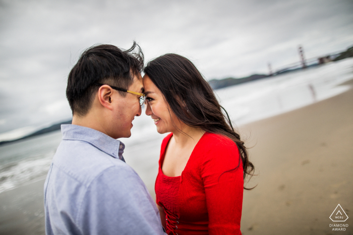 Sessão de retrato de casal na praia de São Francisco de um momento doce e saudável à beira do oceano frio