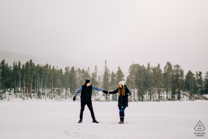 Colorado engaged winter picture session at Sprague Lake in RMNP with the Couple dancing on a frozen lake Colorado engaged winter picture session at Sprague Lake in RMNP with the Couple dancing on a frozen lake