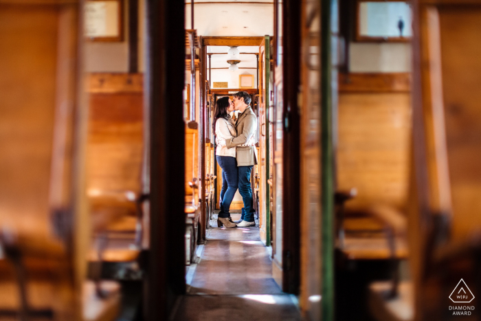 Trieste couple portrait pré-mariage avec Kiss dans un train historique avec beaucoup de bois