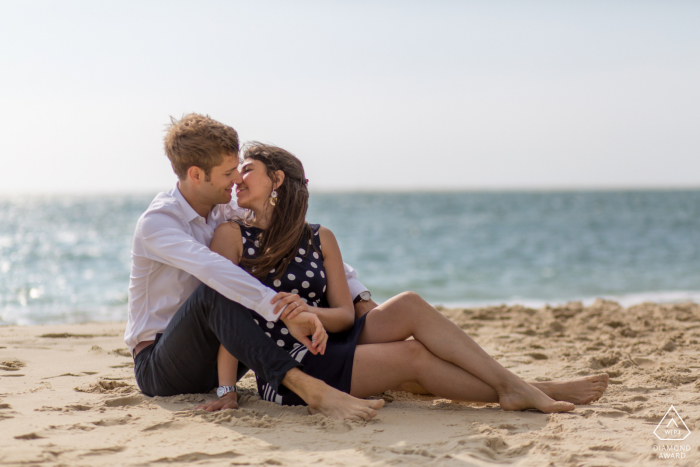 Bassin D Arcachon engaged couple picture session with two lovers by the sea sitting on the sand