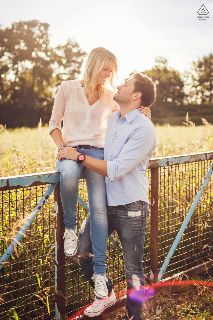 Casal de Dortmund pré-casamento com um casal de pombinhos que ama a luz do sol à tarde sentado em uma cerca