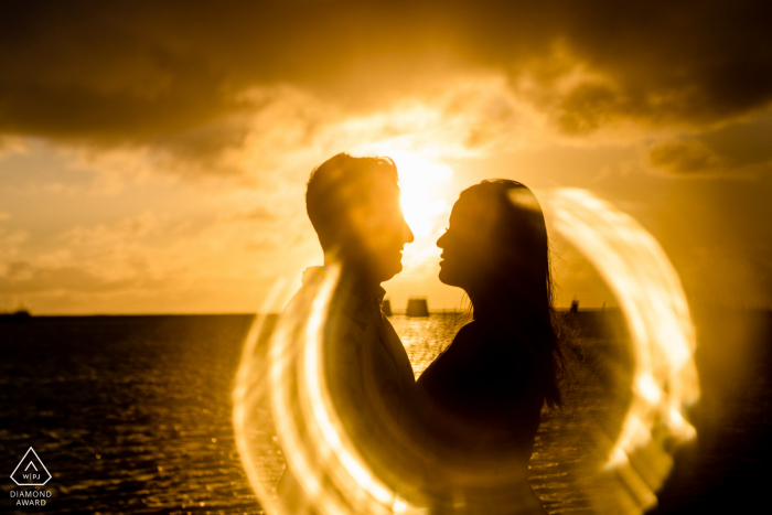 Séance de photo d'engagement de couple Maceio avec quelques fusées de feu à la mer au coucher du soleil